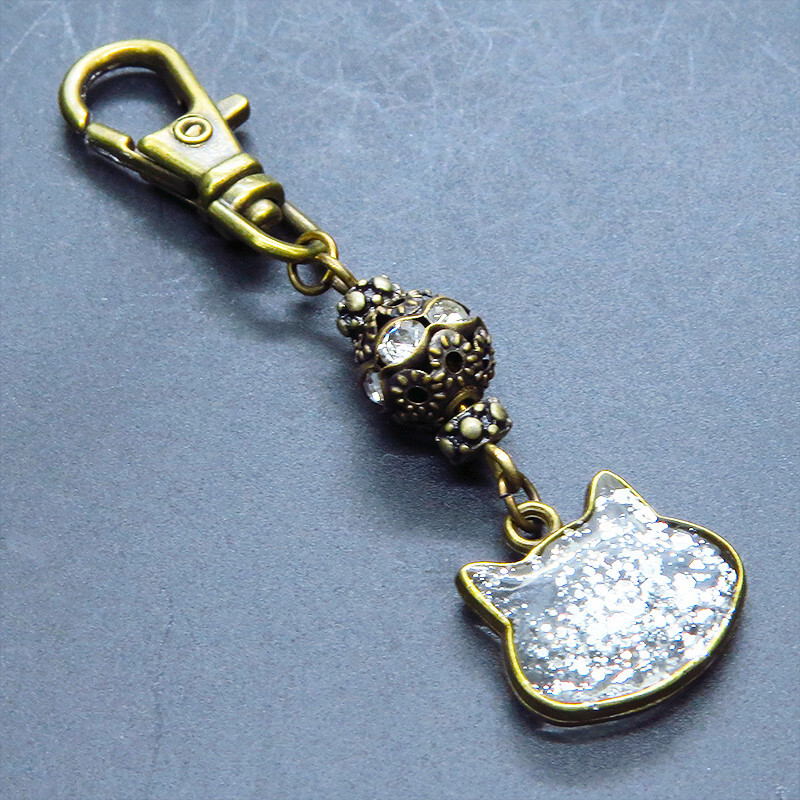 アンティークゴールド 猫フェイスモチーフのクリアカラーレジンのキーホルダー ラインストーン入りメタルビーズ 金具変更可拍卖
