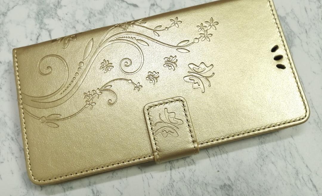 送料込み 手帳型 iPhone14Plus 用 スマホケース 草花 蝶 エンボス 金色拍卖