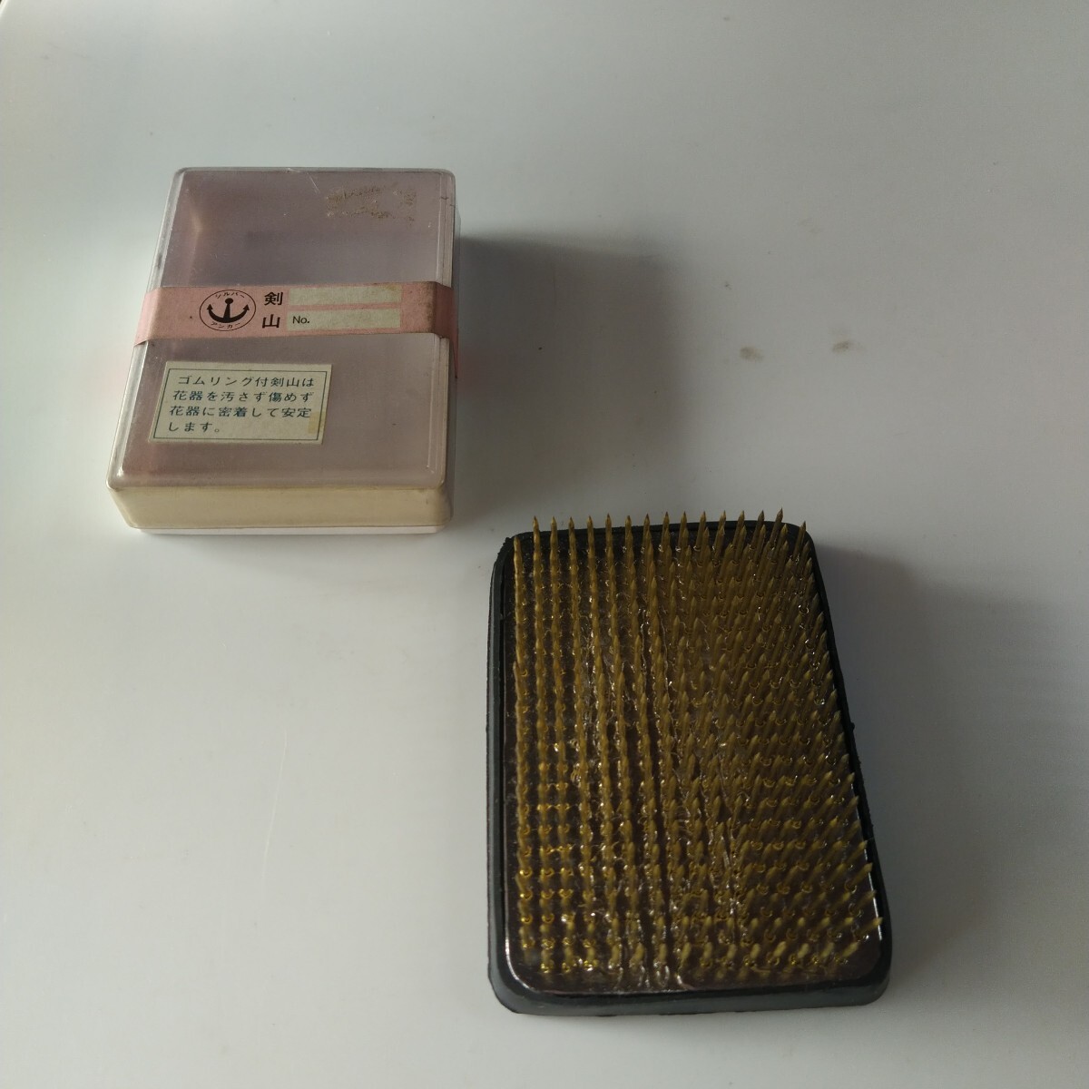 ゴムリング付剣山 ゴムリングを剣山の底に取り付けてから使います。在庫期間長いのでパッケージ汚れありますが未使用です。サイズ9cm×6cm拍卖