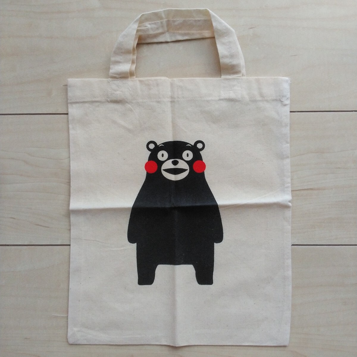 ■『誰もが知ってる熊本県の人気キャラクターくまモンの布製手提げ袋』1袋。手提げ部分を除いた袋の大きさ縦30㎝横25㎝。四つ折り状態。拍卖