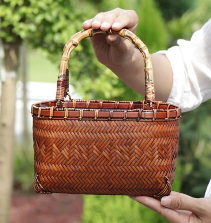 竹編みのバッグ女性の手に砂浜のバッグ日本の着物のお茶のバッグ竹のバスケットの工芸品です拍卖