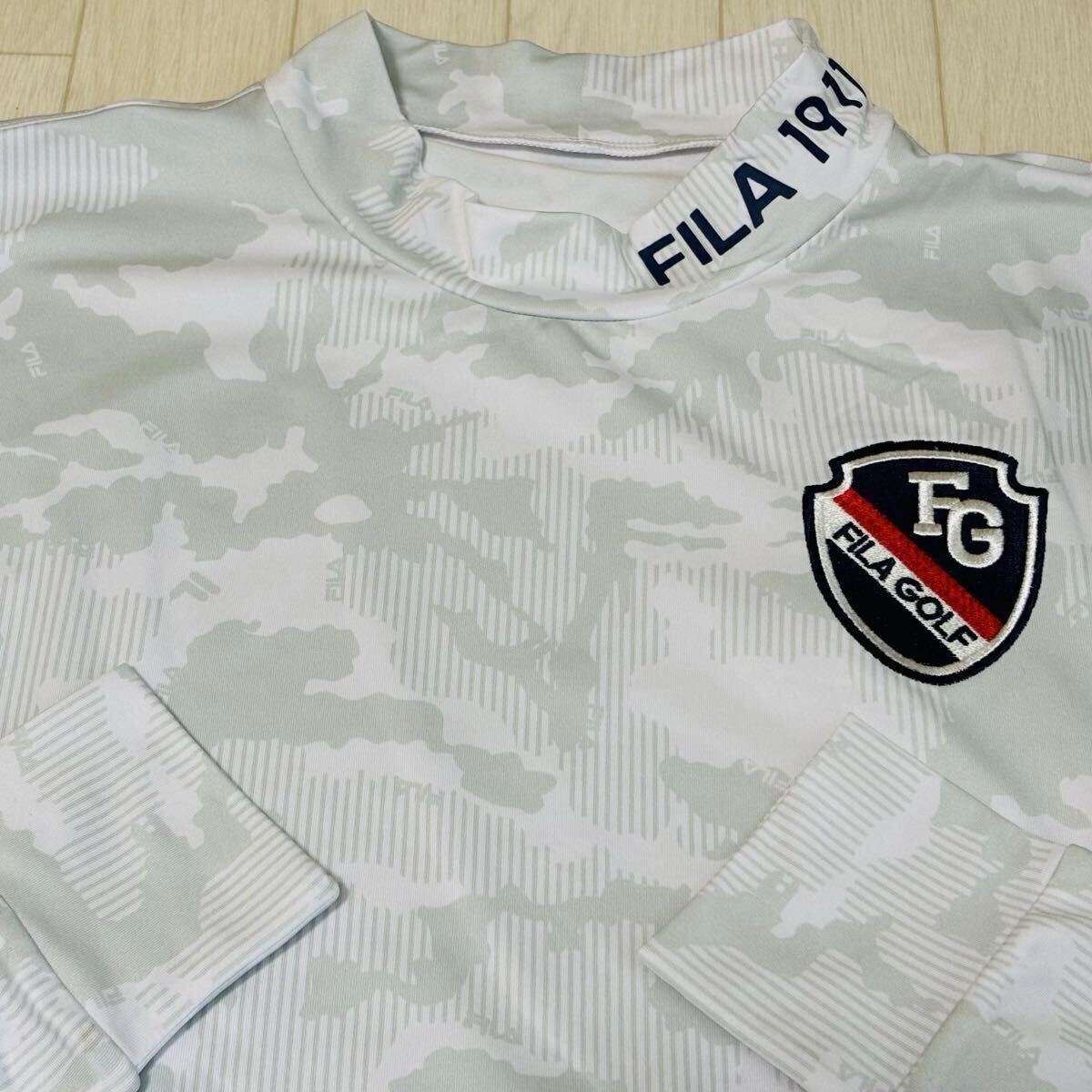 新品★フィラ ゴルフ FILA GOLF カモ柄 左胸FGエンブレム 裏微起毛 保温 長袖モックネックシャツ★ホワイト★サイズL拍卖