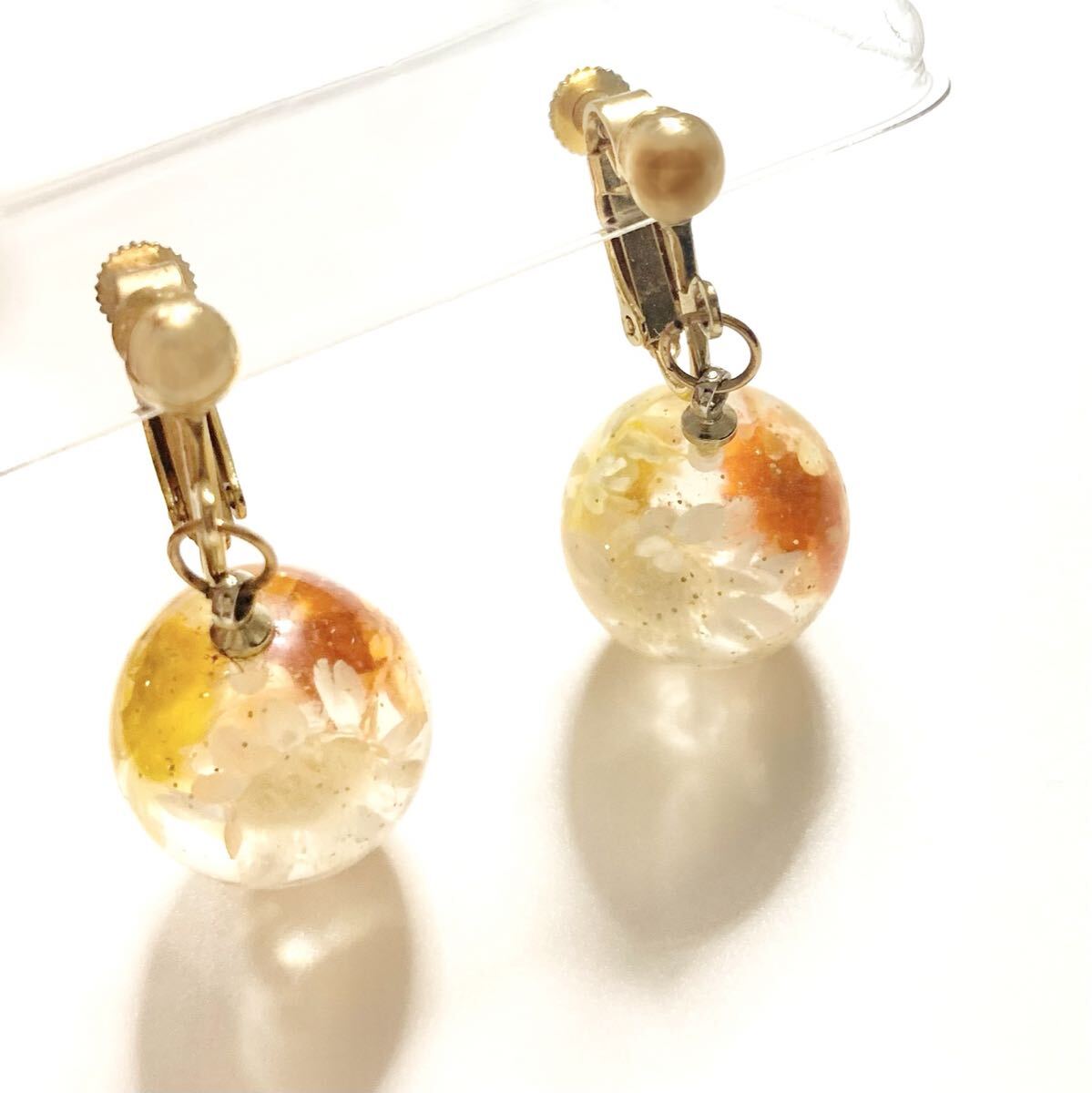 イエローオレンジ系フラワーレジンボールイヤリング クリア 透明 黄色 お花 白 ホワイト アクセサリー拍卖