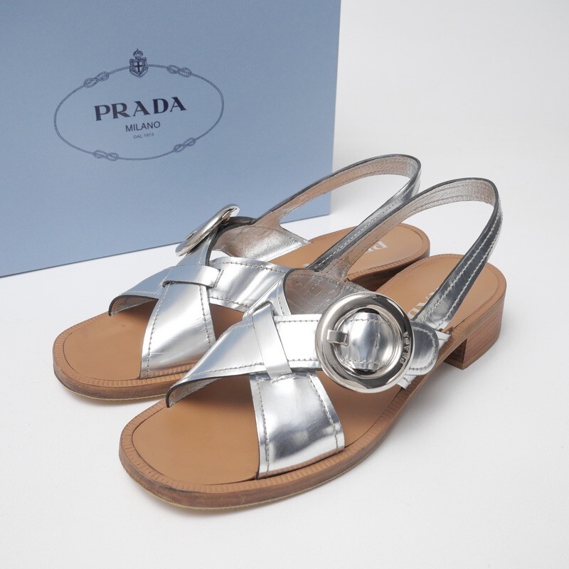 GT4166△イタリア製 PRADA プラダ 38 (24cm相当) メタリックレザー サークルバックル クロスストラップ サンダル 靴 シルバー 箱付き拍卖