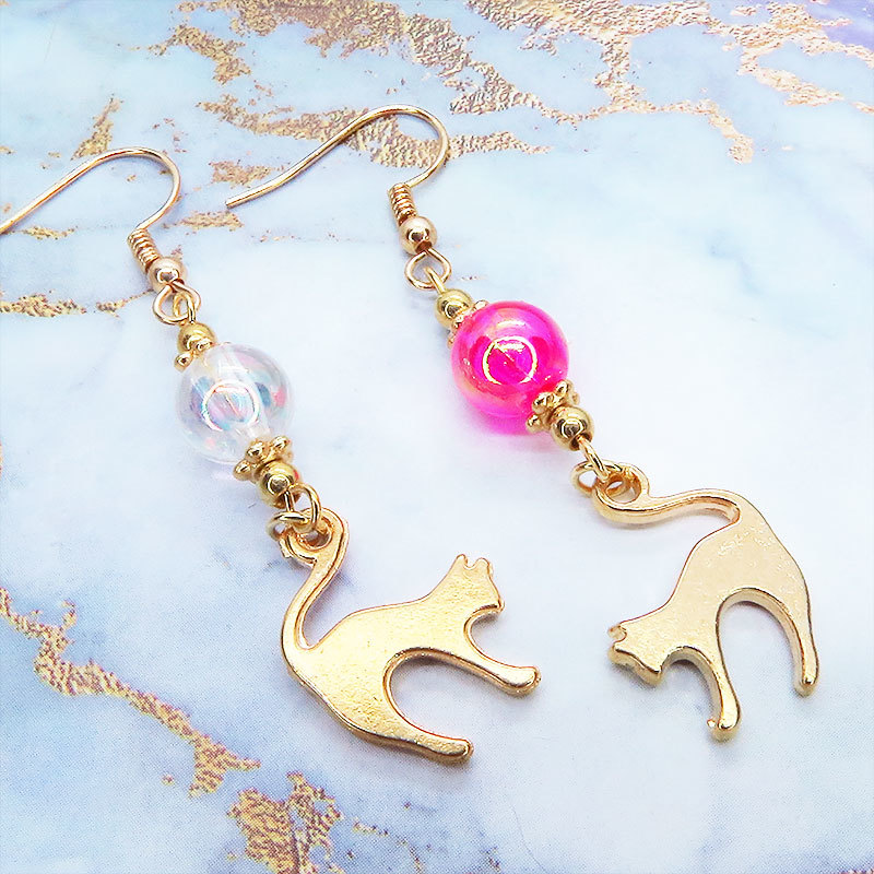 マットゴールドの跳ね猫モチーフと透き通るマゼンダ・クリアのビーズを組合せたピアス拍卖
