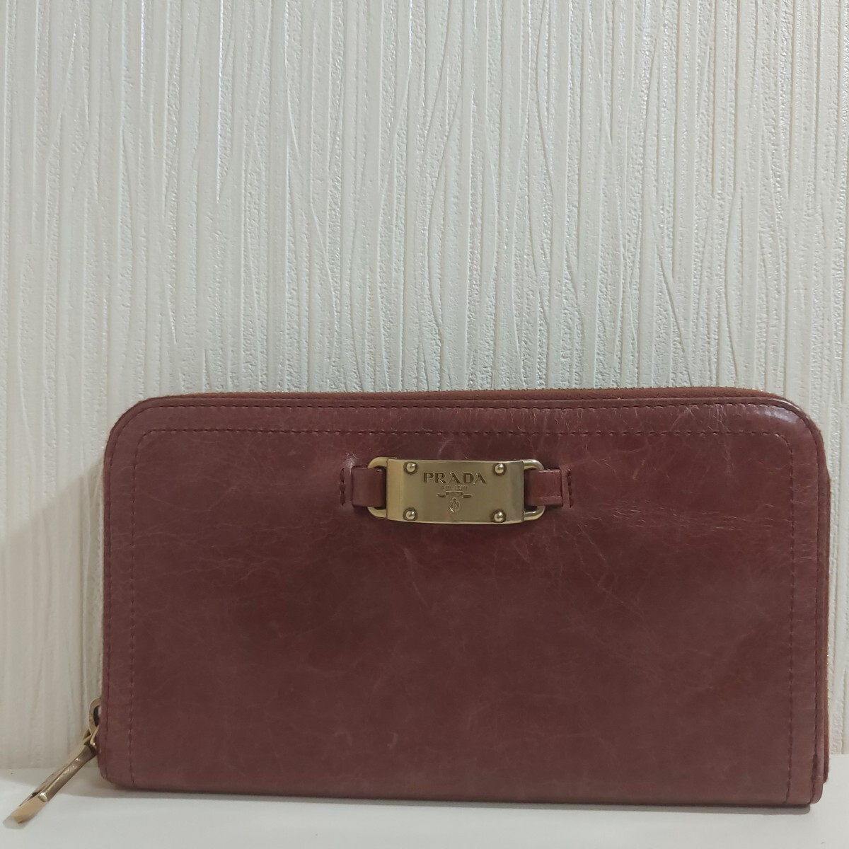 プラダ メタルプレート ラウンドファスナー長財布 レザー ブラウン ゴールド金具 1ML506拍卖