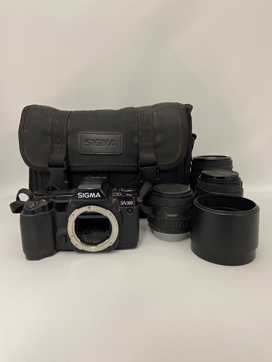 E140★SIGMA シグマ SA-300 フィルムカメラ 一眼レフ レンズ3点付き 動作未確認 ジャンク品