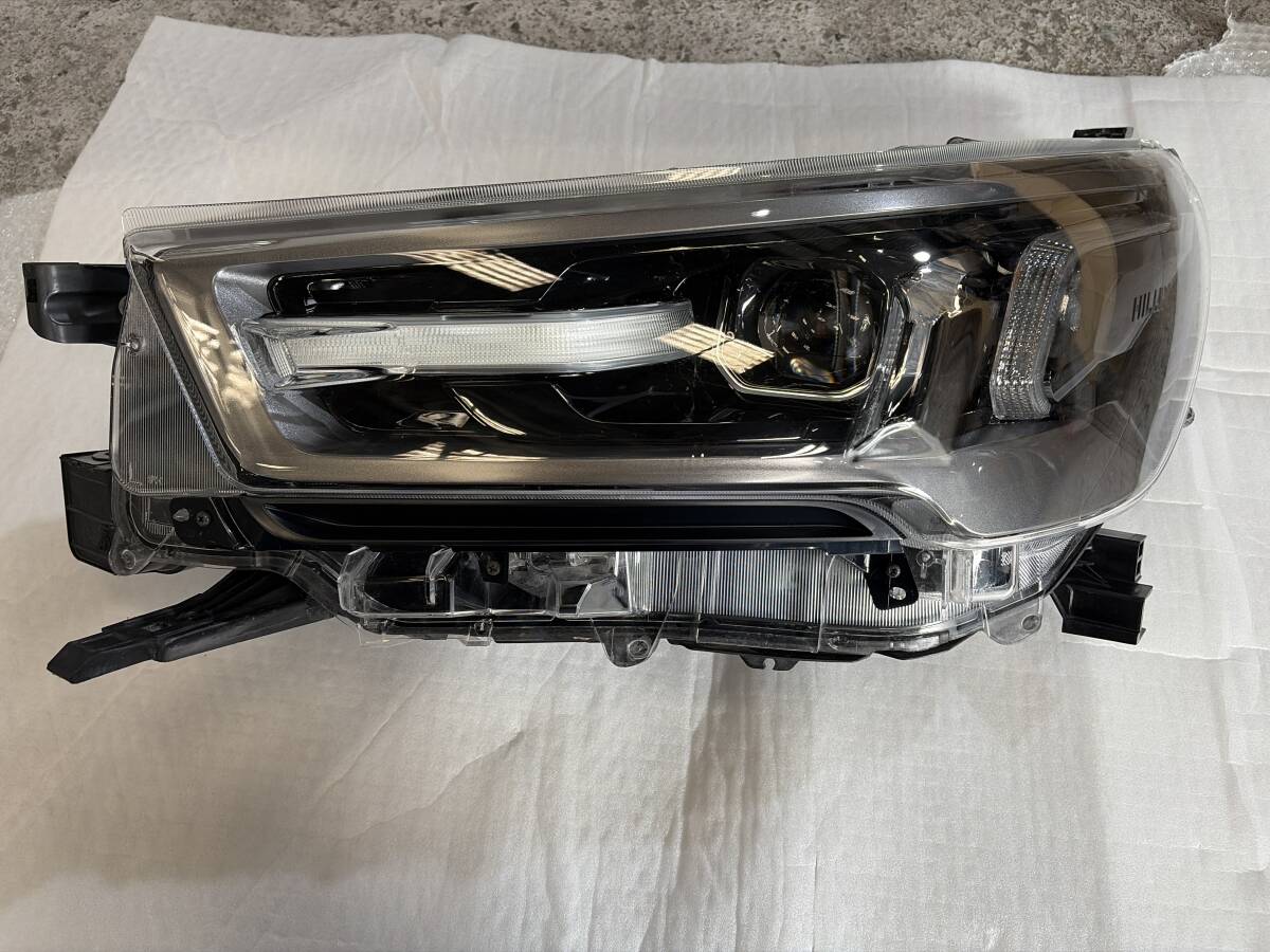 GUN125 ハイラックス　左　ヘッドライト KOITO 0K-180 刻印:GD 純正　トヨタ　取付部補修箇所あり