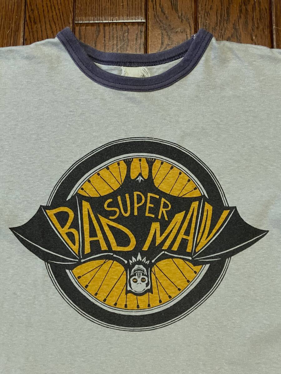 フリーホイーラーズ FREEWHEELERS バッドマン SUPER BAD MAN リンガー Tシャツ グレー ナスコンリブ 両面プリント SUPER VILLAIN 目玉